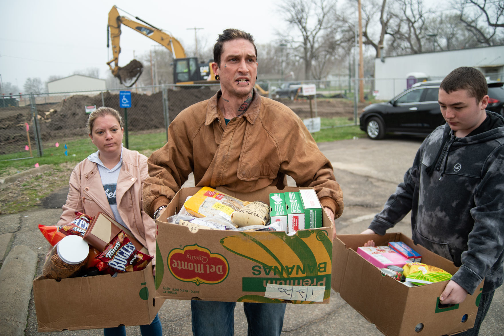 From left, Jackie Smith, Eric Lubrano and James Mullins carry their food from the Flint Hills Breadbasket to the bus stop on Friday. Smith and Lubrano moved back to Manhattan from West Virginia in February and got jobs at McDonaldÕs and Early Edition. Due to the coronavirus pandemic, Smith and Lubrano have been laid off of their jobs for the time being.